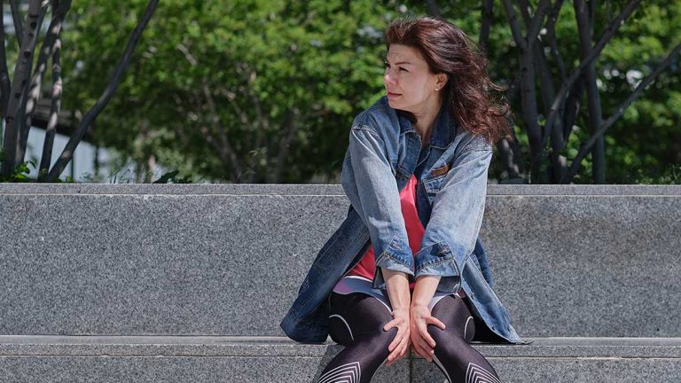 Mujer sentada en el parque haciendo ejercicios pélvicos