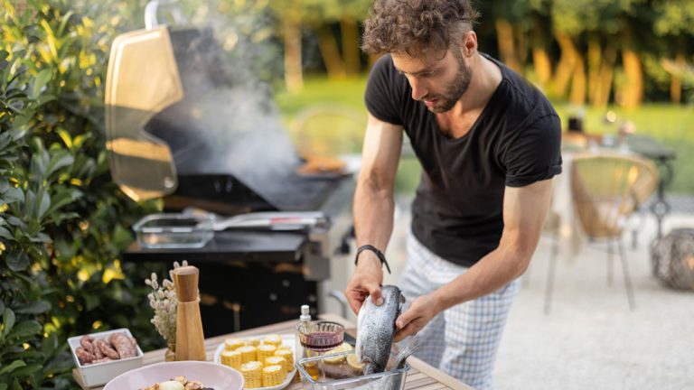 Hombre cocinando en barbacoa al aire libre