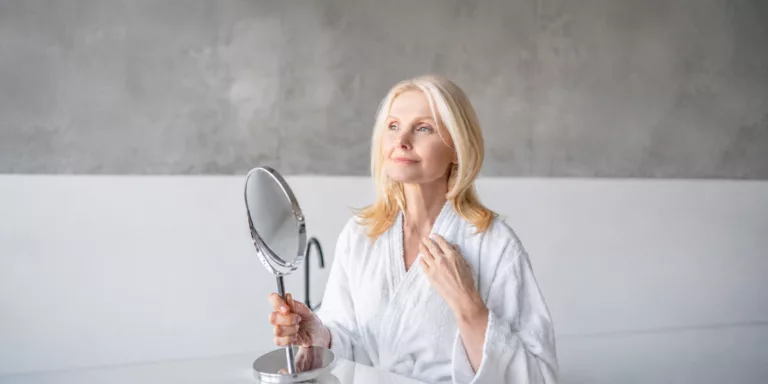 mujer rubia mirándose a un espejo