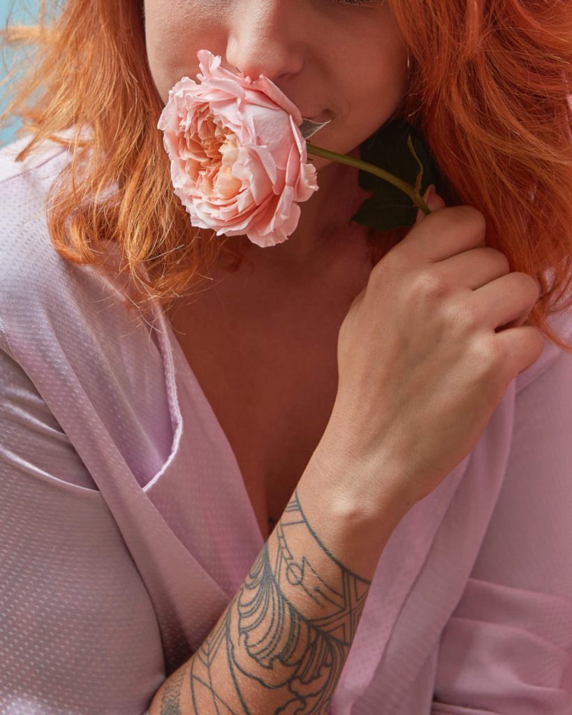 mujer sosteniendo una rosa